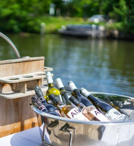 Champagne-emmer met wijnen en bier aan boord van de sloep