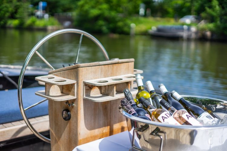 Stuurwiel met wijnen bij de sloep